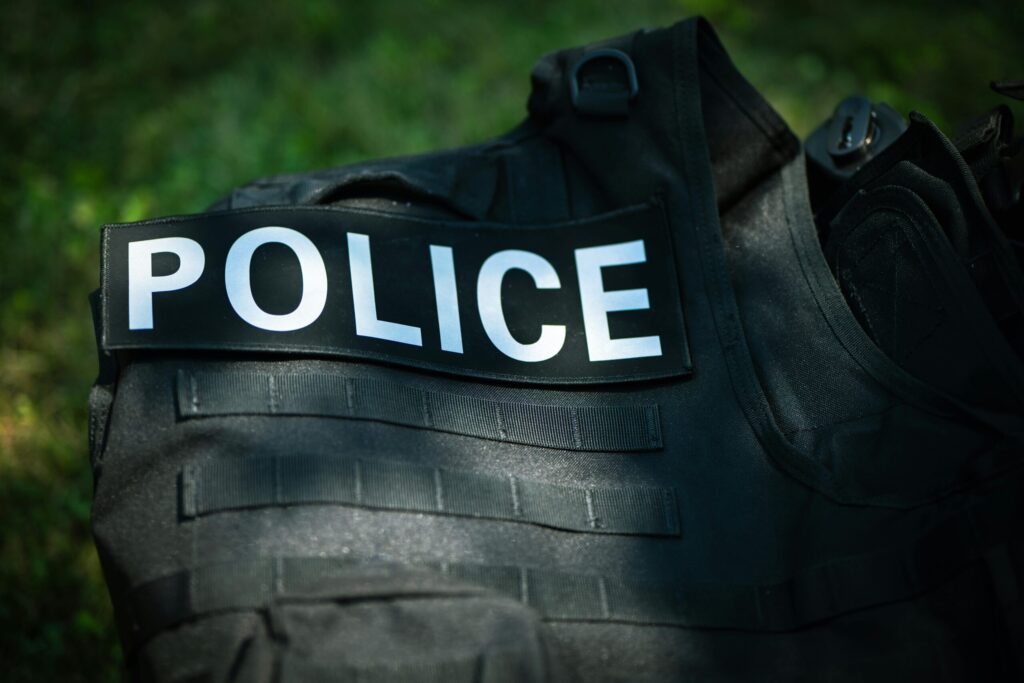 Detailed shot of a police vest lying outdoors, highlighting law enforcement gear.