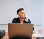 Focused businessman in home office, pondering work thoughts. Perfect for remote work and telecommuting concepts.