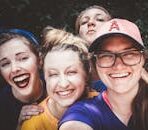 A joyful group of women taking a selfie outdoors, showcasing happiness and friendship.