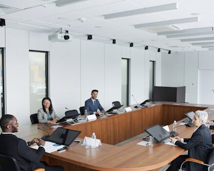 A multicultural group of professionals engaged in a business meeting in a modern conference room.