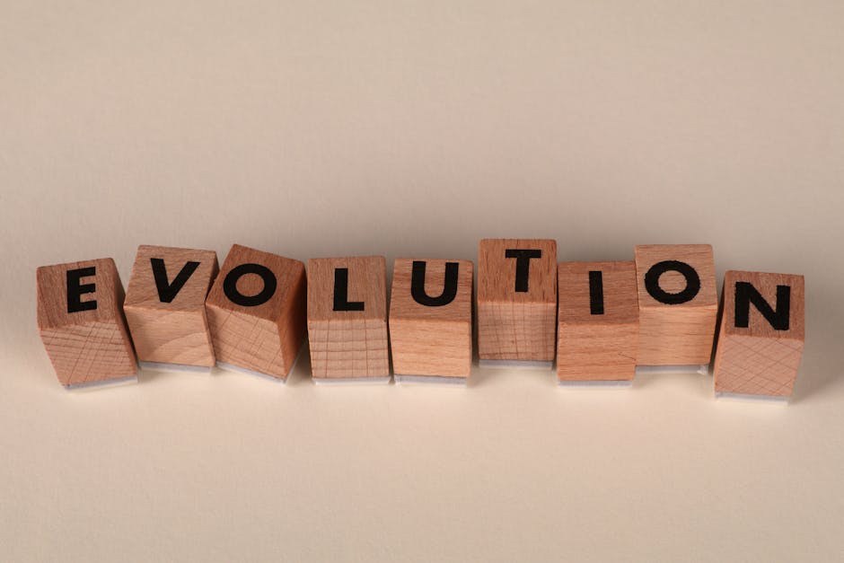 Wooden blocks spelling 'Evolution' on a neutral beige background, symbolizing change and growth.